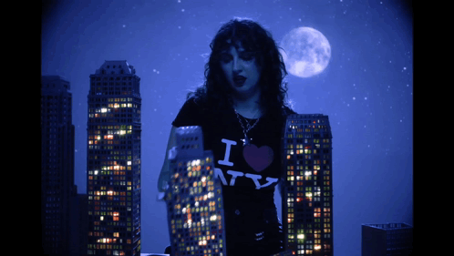 rachel pushing a mini plastic skyscraper with her hand, causing it to fall